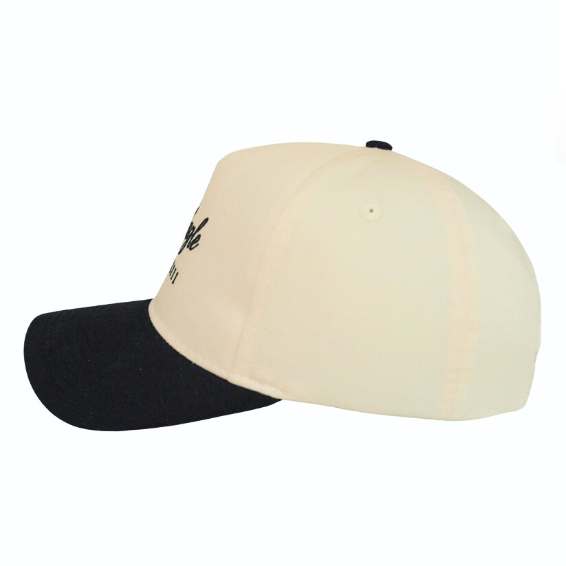 The Heritage Black | Golf Hat is shown from the side on a white background, featuring a cream crown, black curved brim, and UPF50+ sun protection—ideal for today's golfer.