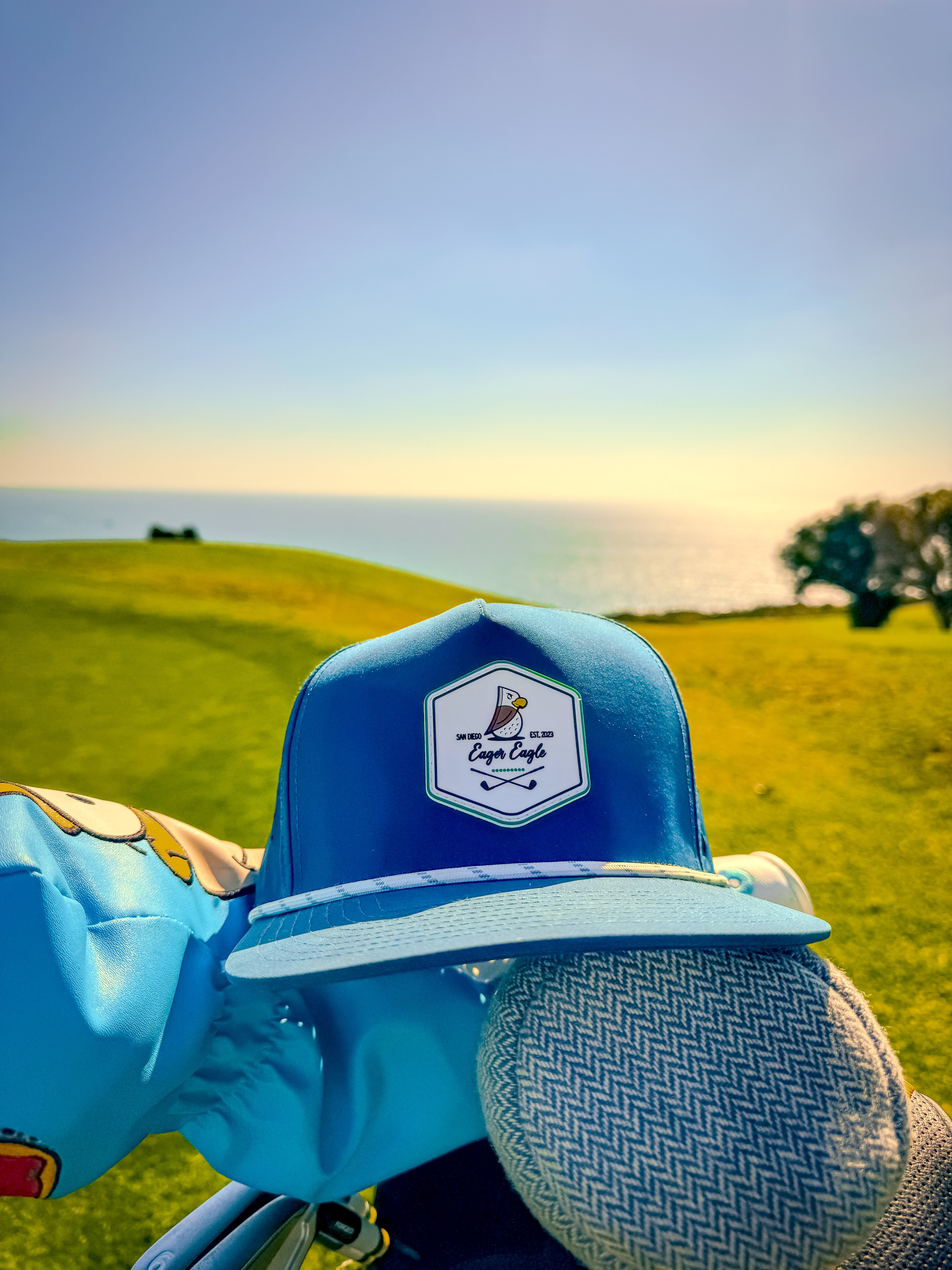 Eager Eagle golf hat with a golf course backdrop