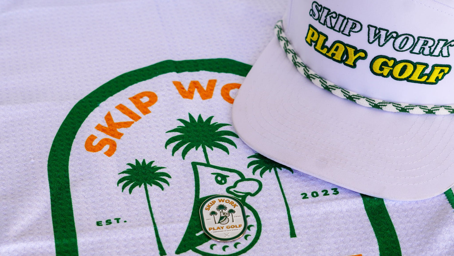White towel with 'Skip Work Play Golf' text and a cap on a white background