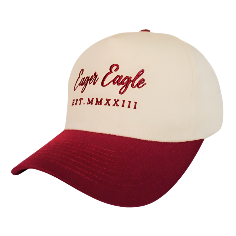 The Oxblood | Golf Hat features Eager Eagle and EST. MMXXIII in red embroidery, a bold red brim, beige crown, and UPF50+ sun protection—perfect for sunny days on the course.