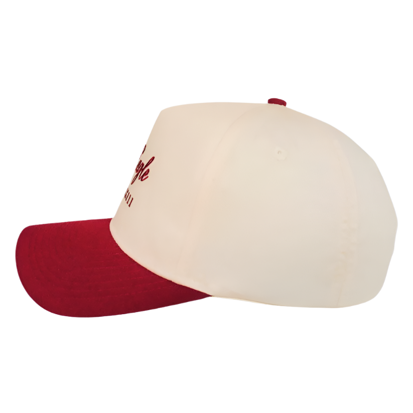 The Oxblood | Golf Hat, seen from the side against a white background, features classic style in cream with a bold red brim and stitching, while delivering UPF50+ sun protection.